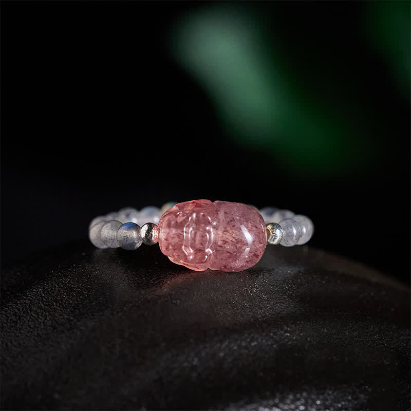 3mm PiXiu Gemstone Ring – Side angle of moonstone bead ring with PiXiu on dark surface, crystals
