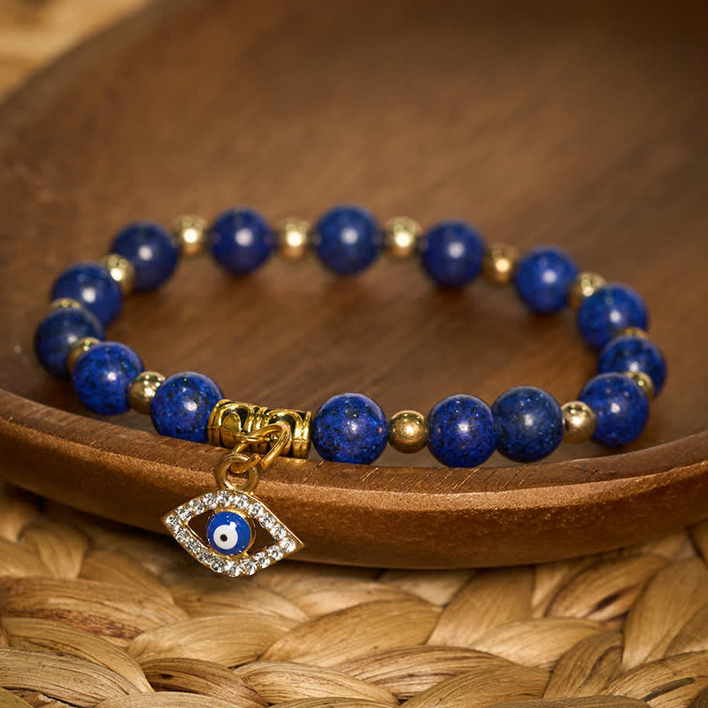 Lapis Lazuli Bracelet – Deep blue lapis beads with gold evil eye charm on wood, protection jewelry