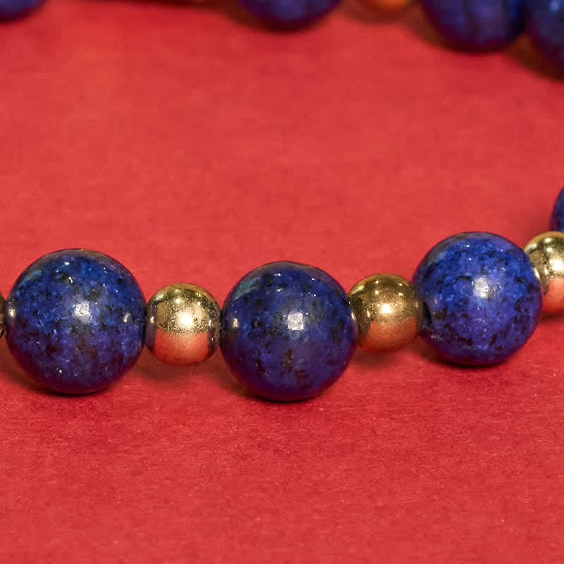 Lapis Lazuli Bracelet – Lapis and gold spacer beads macro detail, crimson red background, natural stone