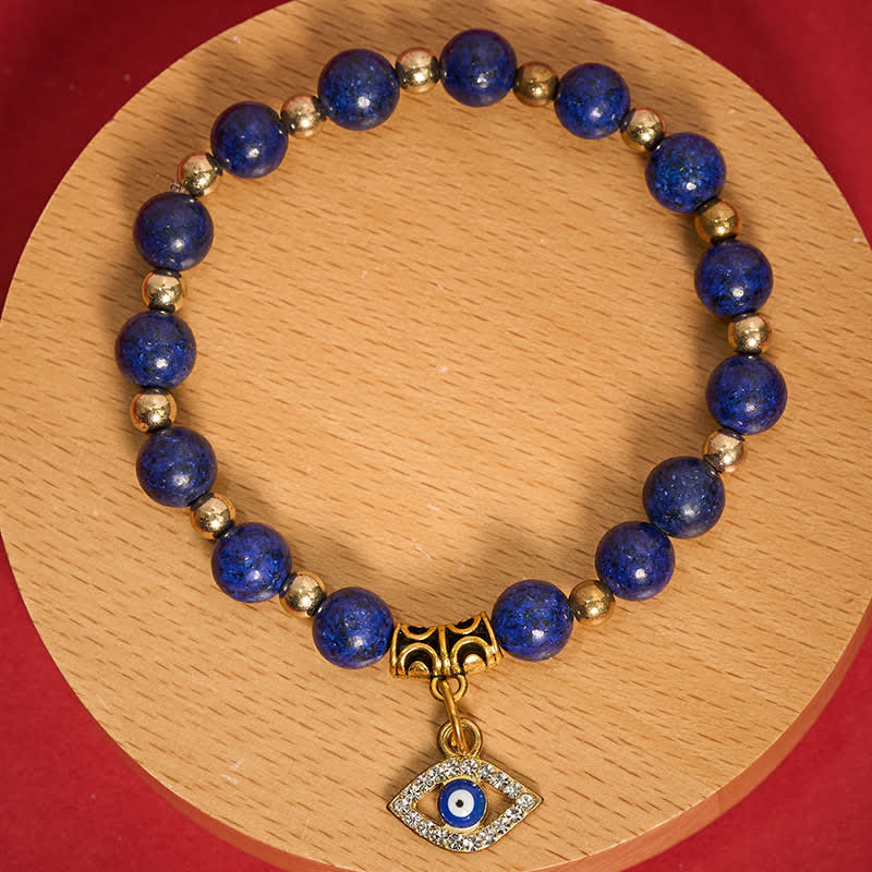 Lapis Lazuli Bracelet – Lapis beads with pave crystal nazar pendant on wood disc, overhead flat lay