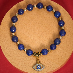 Lapis Lazuli Bracelet – Lapis beads with pave crystal nazar pendant on wood disc, overhead flat lay