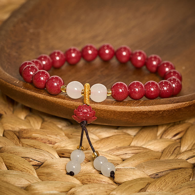 Cinnabar Lotus Enlightenment Bracelet – cradled in hand displaying lotus carving depth and bead translucency, red-toned setting, zen wristlet