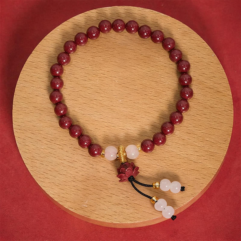 Cinnabar Lotus Enlightenment Bracelet – full circle on wood disc with carved lotus pendant, red backdrop, cinnabar bracelet