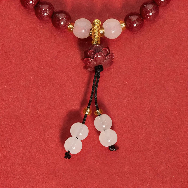 Cinnabar Lotus Enlightenment Bracelet – macro closeup of carved lotus and white accent beads with gold wire, cinnabar talisman