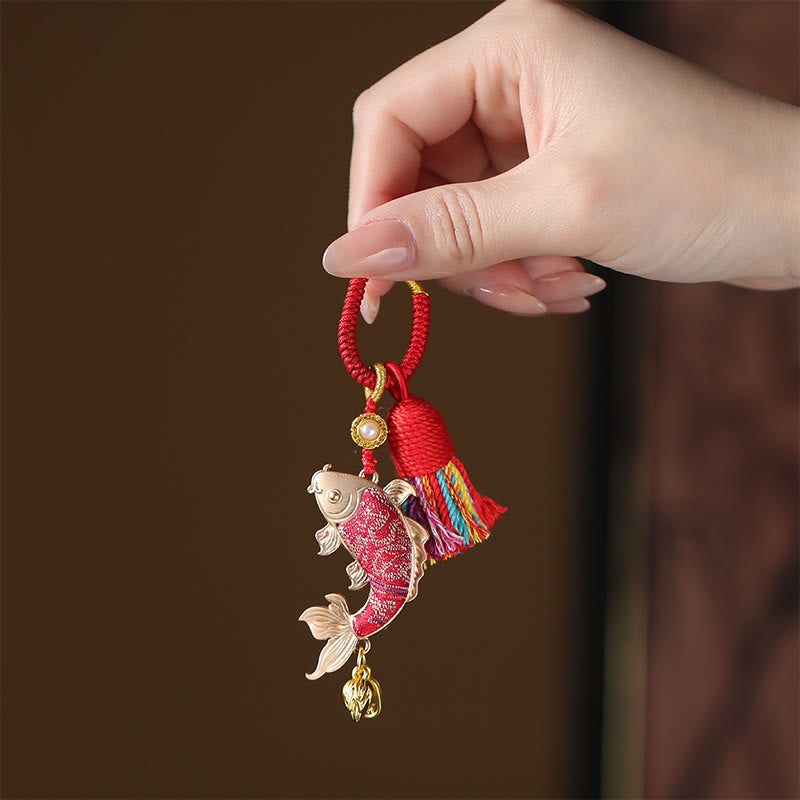 Koi Fish Prosperity Keychain - red koi charm with gold accents and rainbow tassel in hand