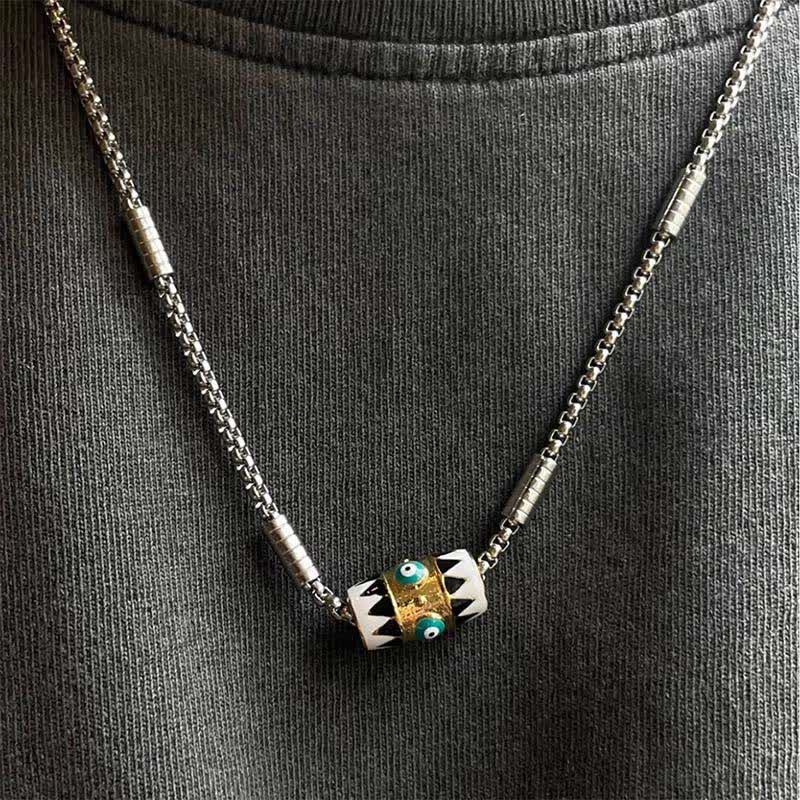 Evil Eye Pendant Necklace – Barrel pendant with dual nazar charms on dark knit shirt, worn lifestyle shot