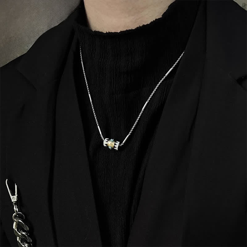 Evil Eye Pendant Necklace – Silver chain with aquamarine evil eye barrel on black blazer, lifestyle jewelry