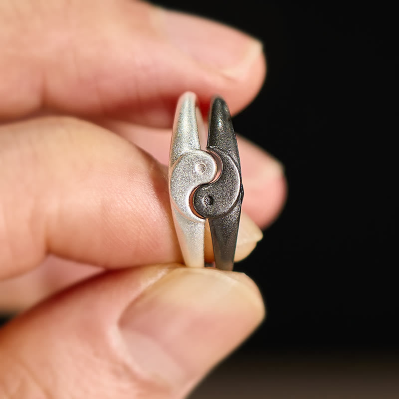 Yin Yang Copper Ring - Side view interlocking yin-yang rings held between fingers, dual finish detail