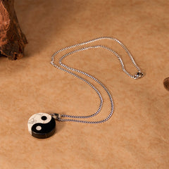 Yin Yang Obsidian Necklace - overhead view of pendant necklace on kraft paper, boho jewelry