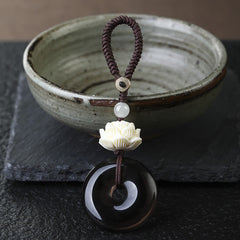 Rainbow Obsidian Lotus Peace Buckle Keychain - angled view of carved lotus and black obsidian disc, spiritual charm