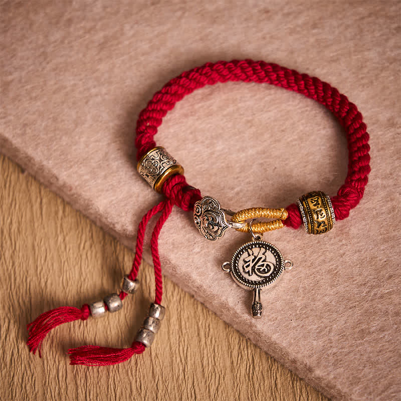 Fu Swastika Rope Bracelet - Red braided Tibetan prayer bracelet with silver prayer wheel pendant on fabric box, handmade rope jewelry