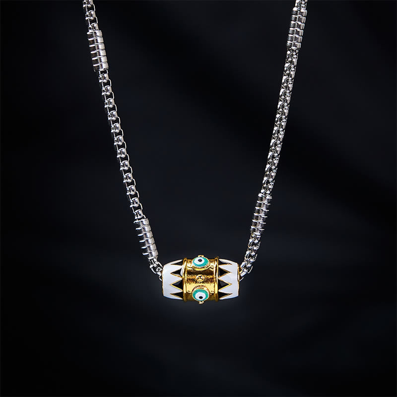 Evil Eye Pendant Necklace – Gold evil eye bead with black tribal pattern on silver chain, black backdrop