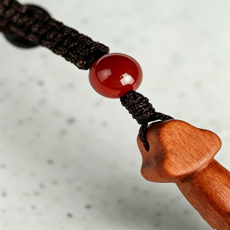Yin Yang Sword Keychain - Detail of braided cord with red carnelian bead connected to carved wooden sword pendant, artisan cr