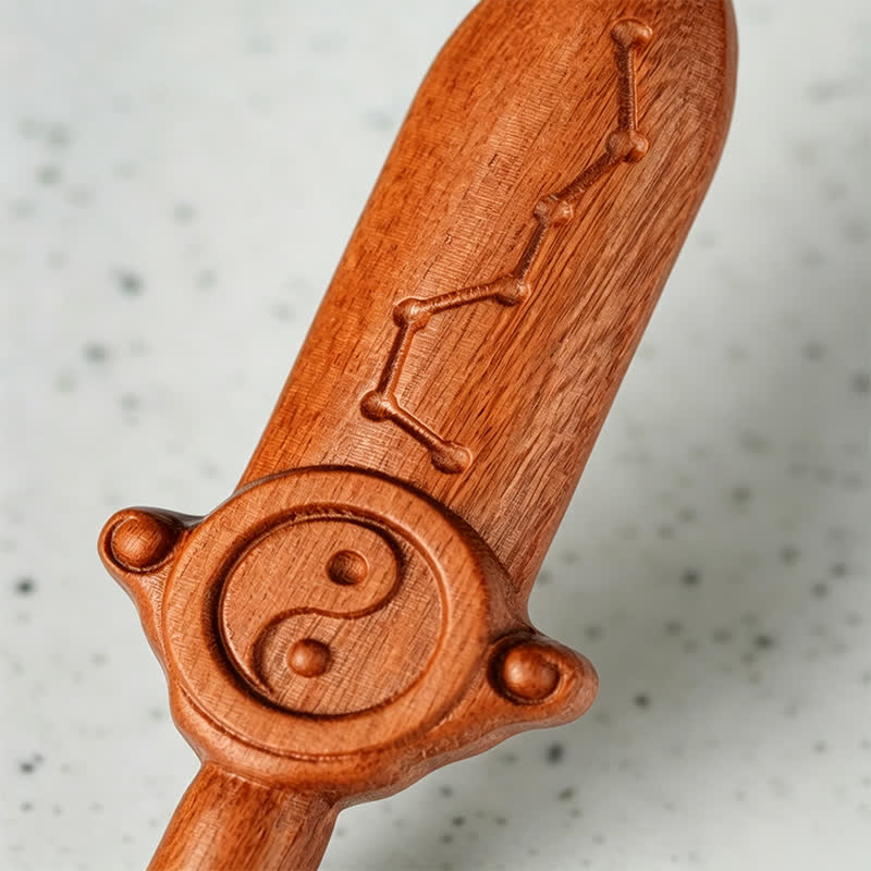 Yin Yang Sword Keychain - Macro detail of carved wooden sword with Big Dipper constellation and yin-yang symbol, natural hard
