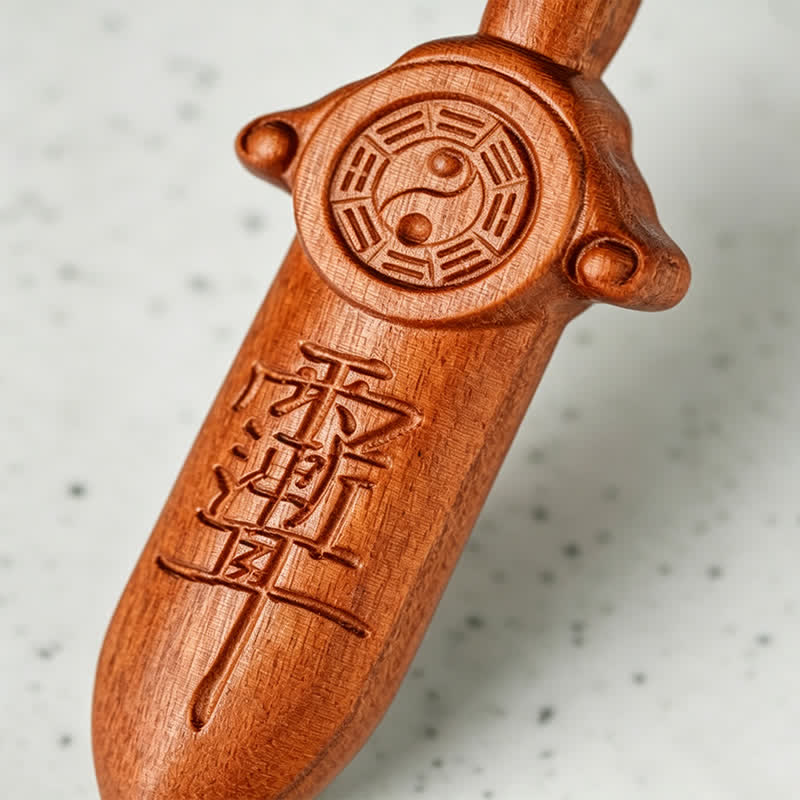 Yin Yang Sword Keychain - Close-up of carved peach wood Taoist sword with yin-yang Bagua and talismanic Chinese characters, m