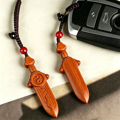 Yin Yang Sword Keychain - Hand-carved wooden sword pendants front and back view with car key for scale, yin-yang and braided 