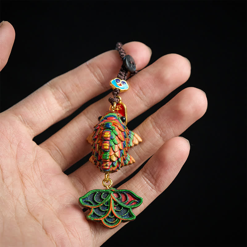 Rainbow Eucalyptus Koi Fish Keychain – hand holding rainbow koi fish keychain with woven scales on black background