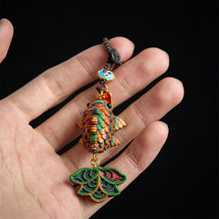 Rainbow Eucalyptus Koi Fish Keychain – hand holding rainbow koi fish keychain with woven scales on black background
