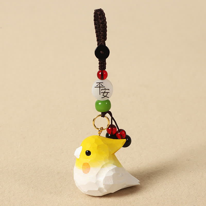 Hand-Carved Wood Cockatiel Om Mani Padm… – Bird keychain with peace blessing bead, red berry dangle, and braided cord, handc…