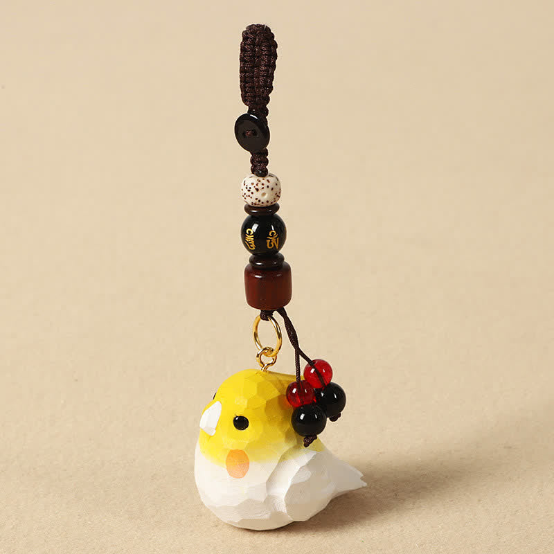 Hand-Carved Wood Cockatiel Om Mani Padm… – Hand-carved yellow cockatiel with braided cord and beaded tassel, wooden bird key… Imagen principal del producto