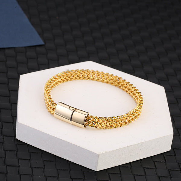 Fish Scale Titanium Steel Magnetic Bracelet – gold-plated double chain on hexagonal pedestal, dark woven background, warm tone