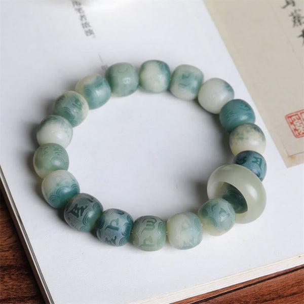 Bodhi Seed Om Mani Padme Hum Bracelet – Arranged on open book with marbled green and ivory beads, meditation beads