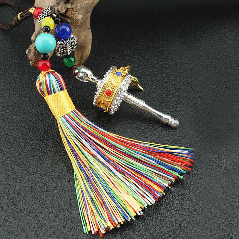 Tibetan Prayer Wheel Tassel – Close-up silver gold prayer wheel with gemstones and green bead cord