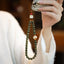 Sandalwood Cat Paw Charm – Green sandalwood bead phone strap with cat paw and kitty bodhi root charms, tea ceremony lifestyle scene