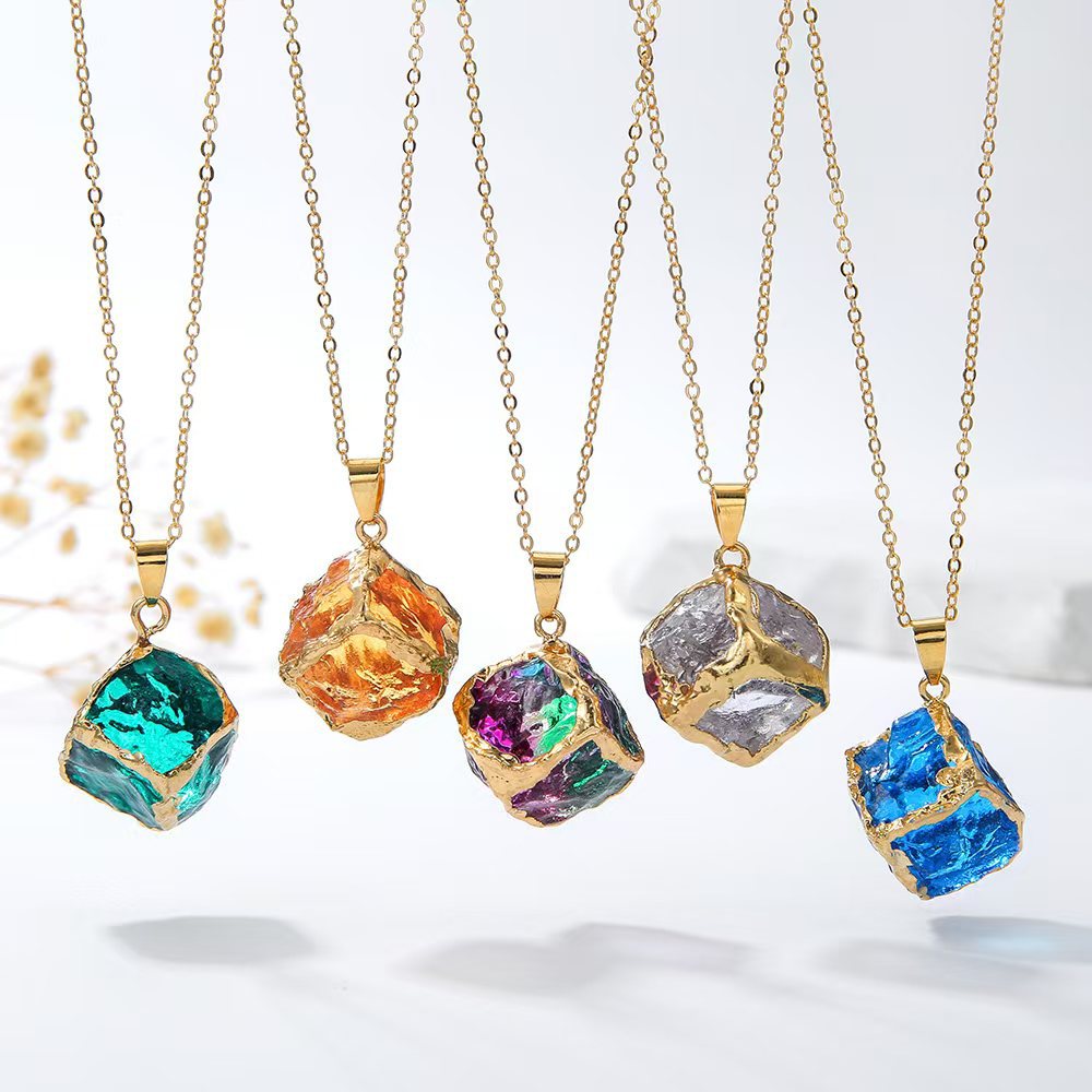 Gemstone Chip Pendant – Six colorful raw crystal cube pendants hanging on gold chains, white background display