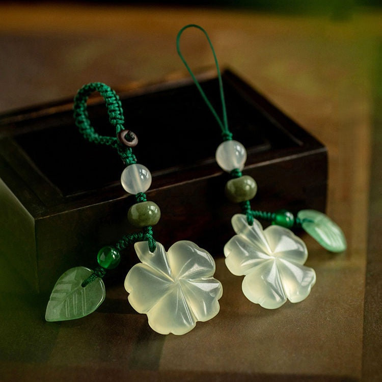 Jade Clover Keychain – two clover pendants displayed together with leaf accents on wood surface