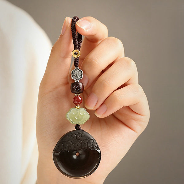 Pixiu Keychain – hand holding ice obsidian disc charm with jade cloud and red agate bead