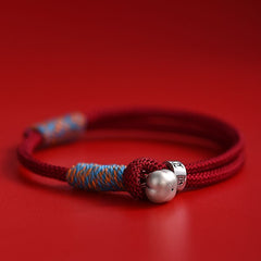 Persimmon Cord Bracelet – Red braided cord with silver persimmon charm on red background, luck bracelet