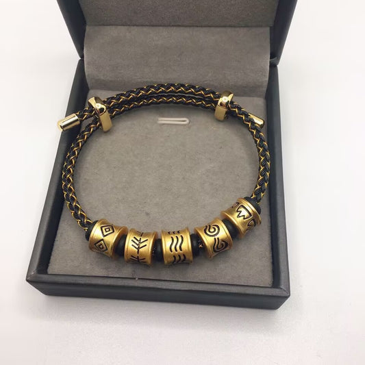 Five Elements Bracelet – black gold braided cord with five engraved gold beads in open black gift box, luxury presentation