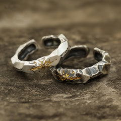 Self-Discipline Ring – Two stacked silver rings with gold sun motifs on textured stone, meditation jewelry