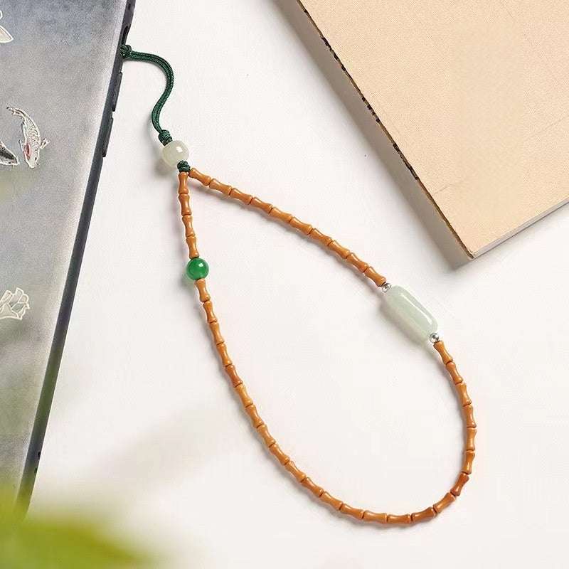 Olive Kernel Phone Chain – olive bead phone lanyard flat lay with beige book on white desk, boho phone chain