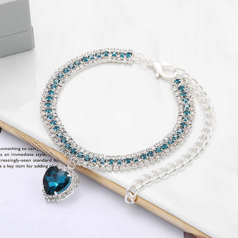 Crystal Rhinestone Pet Collar – Teal rhinestone band with sapphire heart pendant on white, bling pet necklace