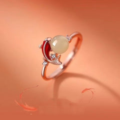 Koi Jade Ring – rose gold band with red enamel koi fish and Hetian jade bead, orange backdrop with fish motifs, diamond accents, feng shui jewelry