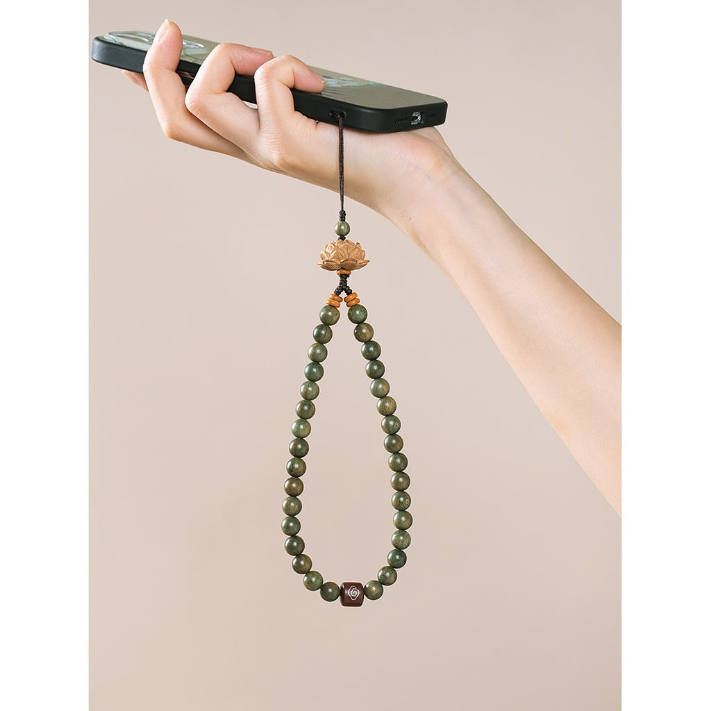 Zodiac Wood Bead Lanyard – Female hand gripping phone with green wood bead lotus strap hanging, usage scenario portrait