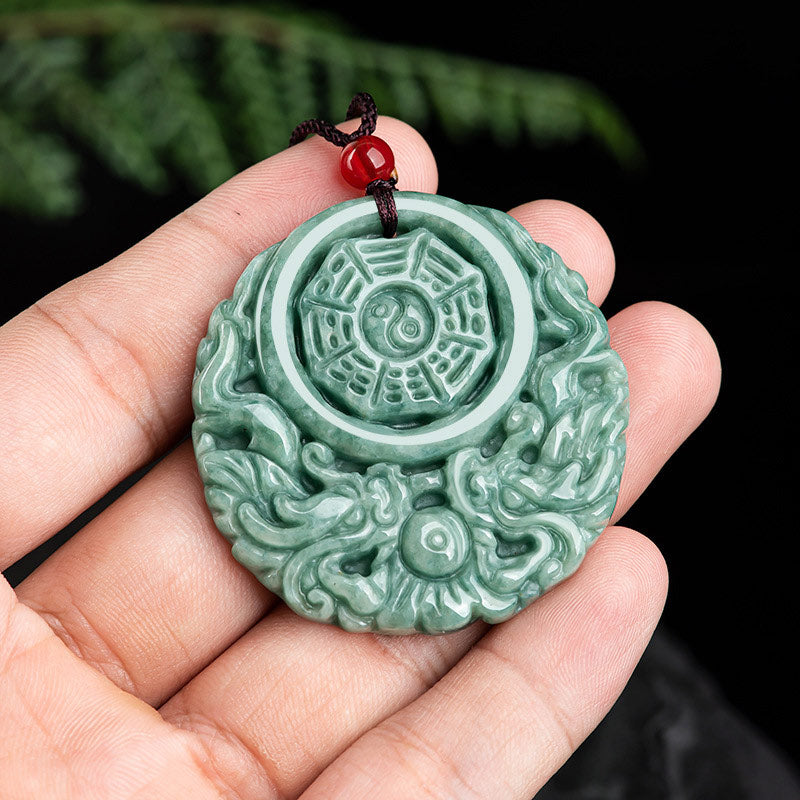 Dragon Jade Yin Yang Necklace – Green jade pendant on black cord held by fingertip, warm brown blurred background, elevated close-up