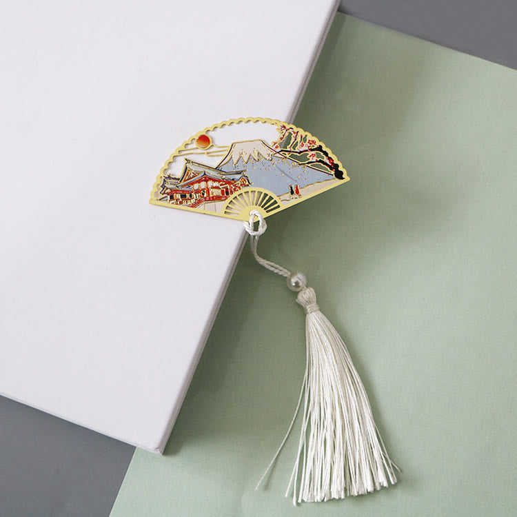 Brass Hollow Fan Bookmark - Landscape and pagoda cutout with white tassel on book, zen