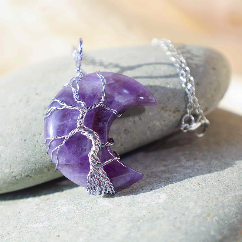 Quartz Crystal Moon Tree of Life Pendant – amethyst crescent on gray river stone with natural daylight, healing crystal