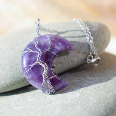Quartz Crystal Moon Tree of Life Pendant – amethyst crescent on gray river stone with natural daylight, healing crystal