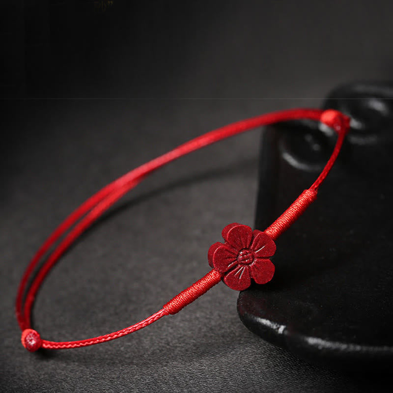 Cinnabar PiXiu Lotus Koi Fish Blessing Braid Bracelet – red flower bracelet draped on black ceramic vase, cinnabar protection accessory