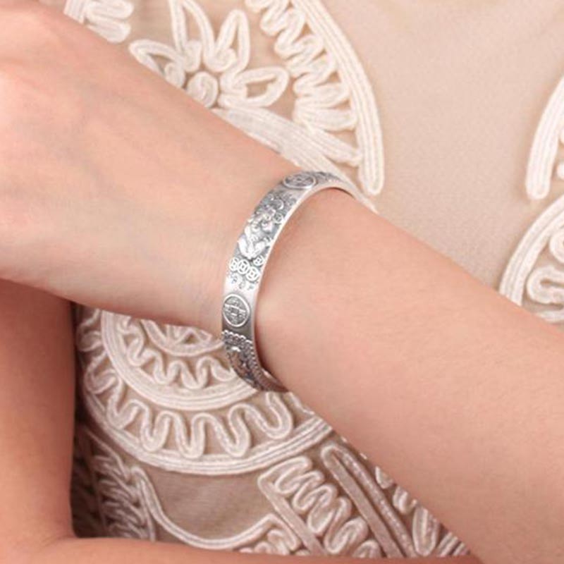 Sterling silver Pixiu cuff bracelet worn on wrist, antique finish with decorative relief patterns, traditional Chinese feng shui wealth jewelry