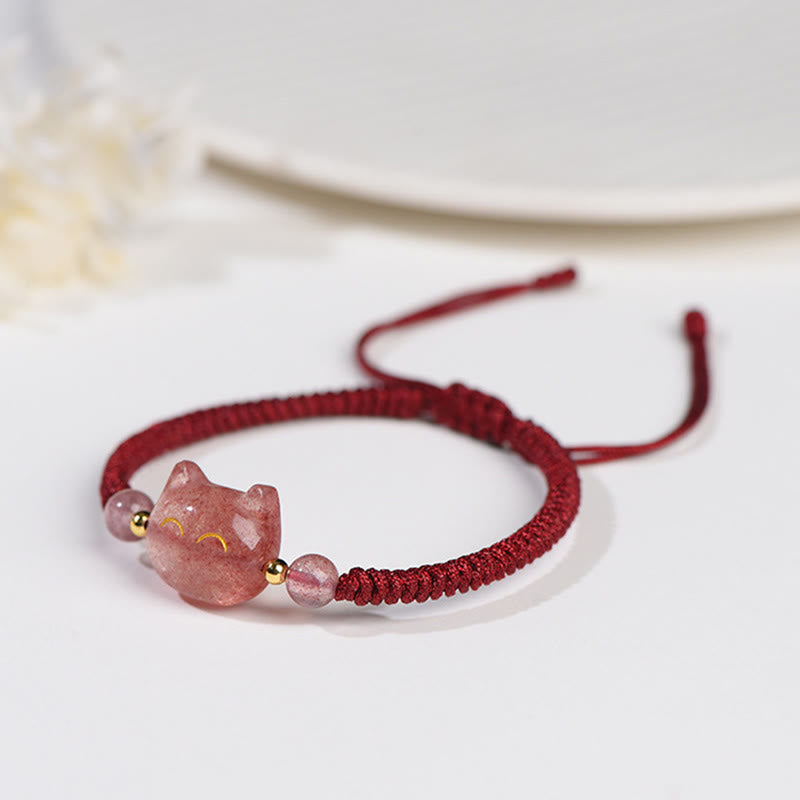 Strawberry quartz cat head bracelet with gold smile details on burgundy woven cord, adjustable sliding knot closure on white background