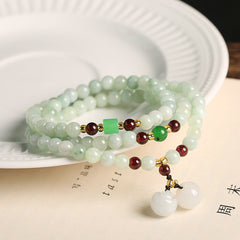 Jade Pixiu Maitreya Buddha Abundance Bracelet – On white ceramic plate with jade apple pendant, prosperity