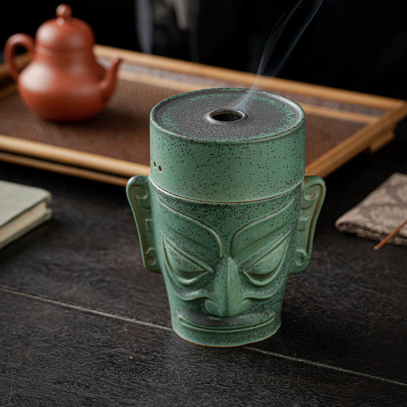 Sanxingdui Bronze Mask Incense Burner – Elevated view with smoke trail, Yixing teapot and incense on dark wood