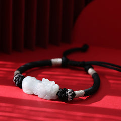 Natural Jade PiXiu Bracelet – flat lay on red surface with shadow, black adjustable cord, jade prosperity