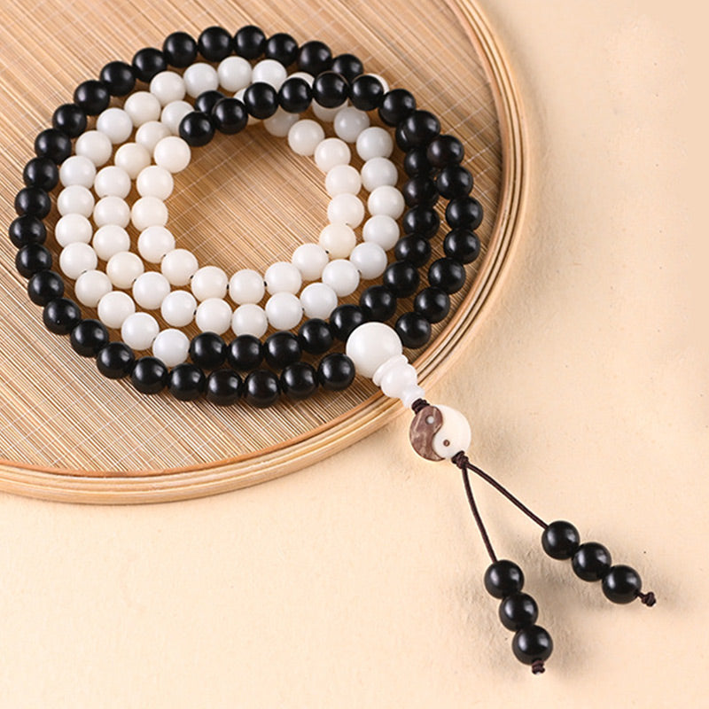 Ebony Yin Yang Protection Mala - coiled on bamboo tray with yin-yang accent, wooden mala
