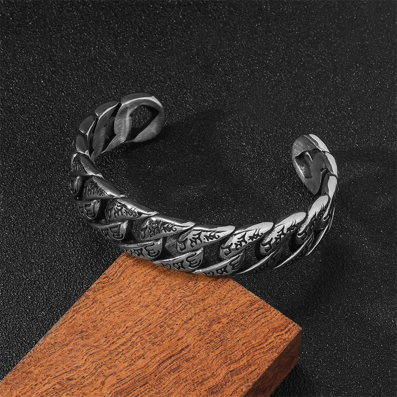 Tibetan Om Mani Padme Hum Cuff Bangle – elevated angle on dark surface, engraved scale links, antique silver finish